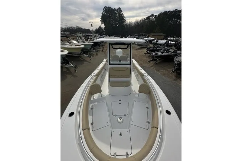 Slide: The Image of 2026 Sportsman Heritage 231 Center Console boat, sleek design, spacious deck, parked outdoors. - 9