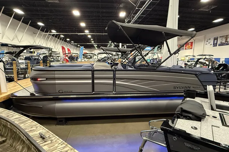 The Image of 2025 Sylvan G3 SLZ pontoon boat displayed indoors with sleek design and canopy. - 1
