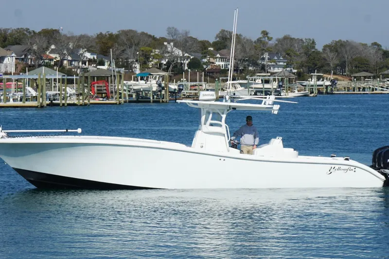 Slide: The Image of 2007 Yellowfin 36 Offshore boat on calm water near a marina. - 10