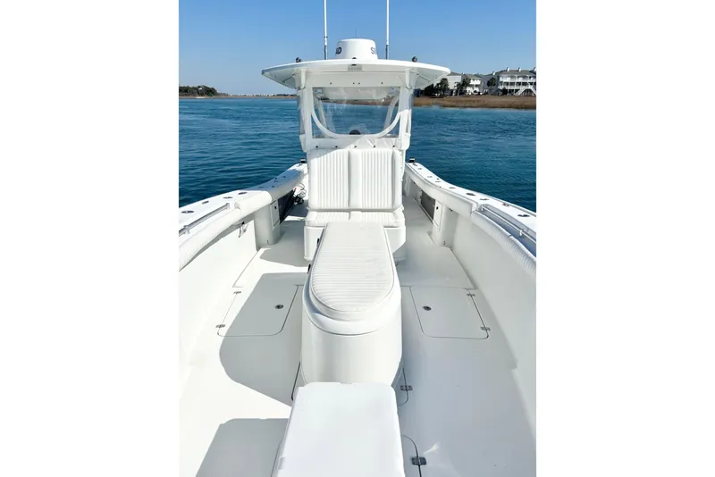 Slide: The Image of 2007 Yellowfin 36 Offshore boat on calm water, showcasing spacious deck and seating. - 16