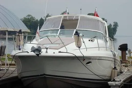 Slide: The Image of 1995 Silverton 361 Express yacht docked by a serene lakeside. - 3