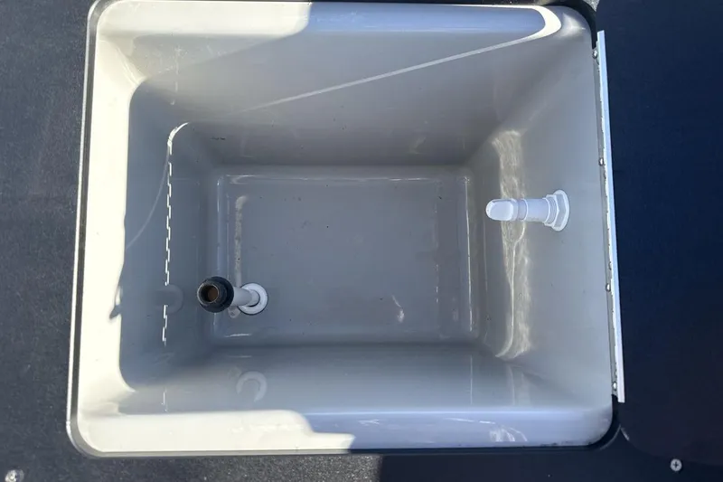 Slide: The Image of Empty storage compartment in 2023 Viaggio Del Mar 18F boat, featuring drainage fittings. - 19
