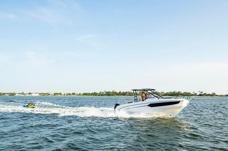Slide: The Image of 2026 Beneteau Flyer 8 SUNdeck cruising on open water, towing a tube with passengers. - 15