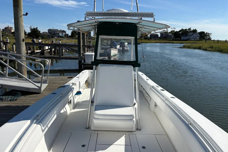 Slide: The Image of 2001 Contender 31 Open boat docked by a serene waterfront on a sunny day. - 7