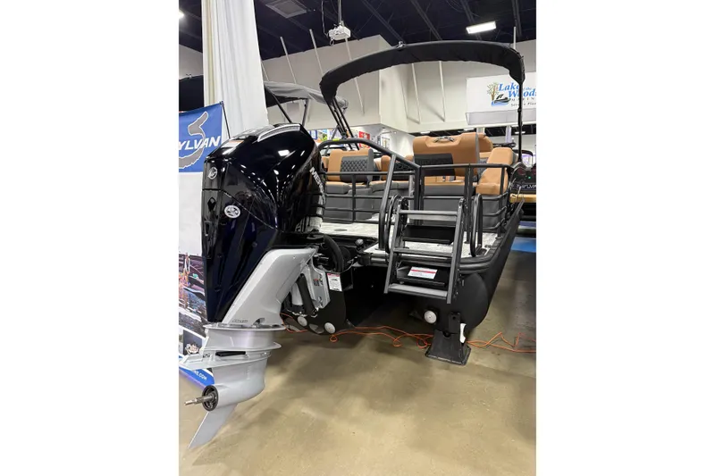 Slide: The Image of 2026 Sylvan L3 SLZ pontoon boat with powerful outboard motor displayed indoors. - 13