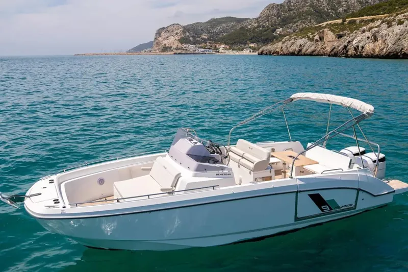 Slide: The Image of 2026 Beneteau Flyer 9 SPACEdeck boat on clear blue water near rocky coastline. - 2
