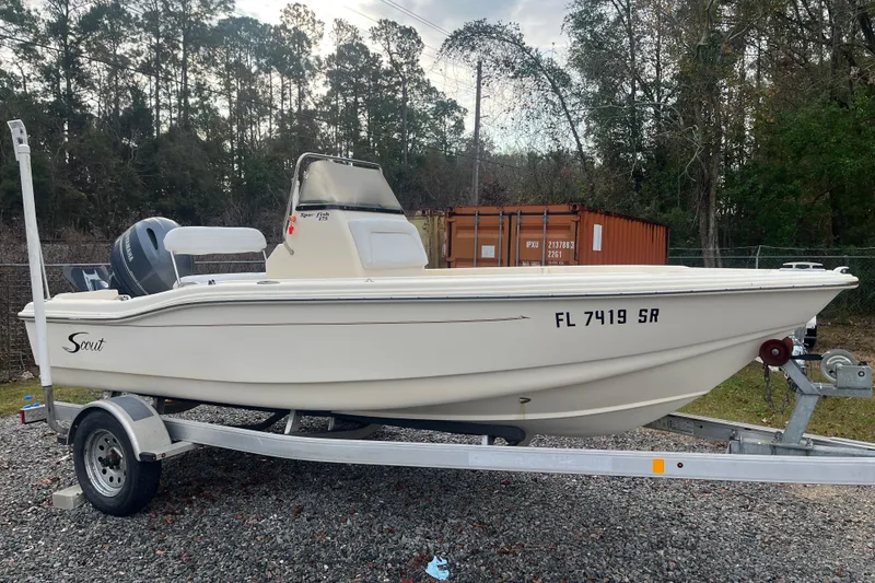 The Image of 2019 Scout 175 Sportfish boat on trailer, parked outdoors with trees in background. - 0