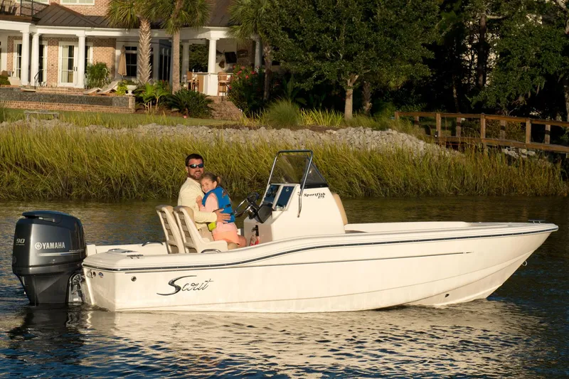 Slide: The Image of Manufacturer Provided Image: 2019 Scout 175 Sportfish boat on a calm river near a house. - 13