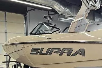 The Image of 2026 Supra SL boat in a showroom, showcasing sleek design and modern features. - 2