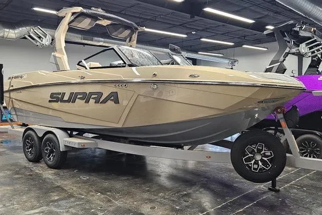 Slide: The Image of 2026 Supra SL boat on trailer in showroom, beige color, sleek design. - 7