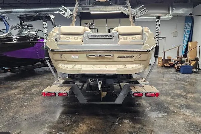 Slide: The Image of 2026 Supra SL boat in showroom, rear view with swim platform and wakeboard racks. - 9