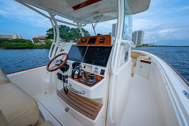 Slide: The Image of 2018 Hunt Yachts 32 Center Console, luxurious helm with advanced navigation, on serene waters. - 10