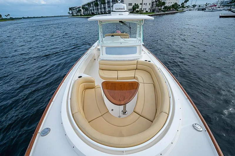 Slide: The Image of 2018 Hunt Yachts 32 Center Console with tan seating and wooden table on open water. - 11