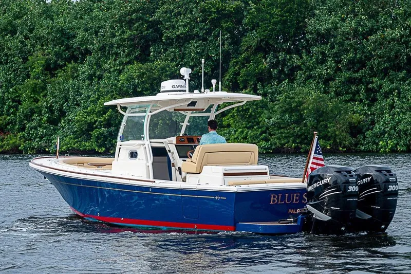 Slide: The Image of 2018 Hunt Yachts 32 Center Console cruising on water, featuring dual Mercury engines. - 21