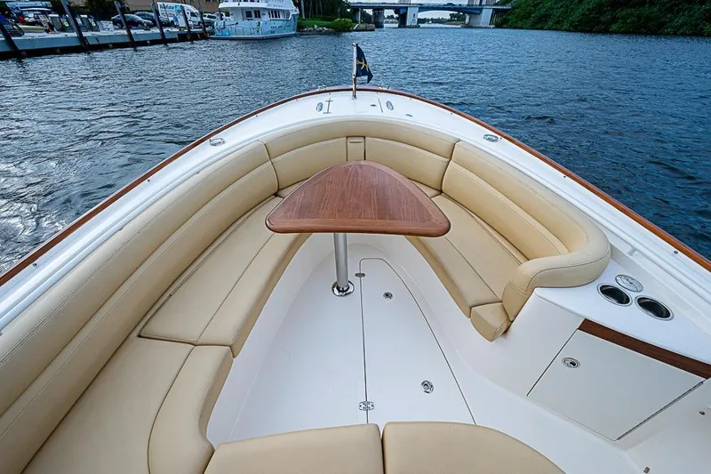 Slide: The Image of 2018 Hunt Yachts 32 Center Console with elegant seating and wooden table on calm waters. - 12