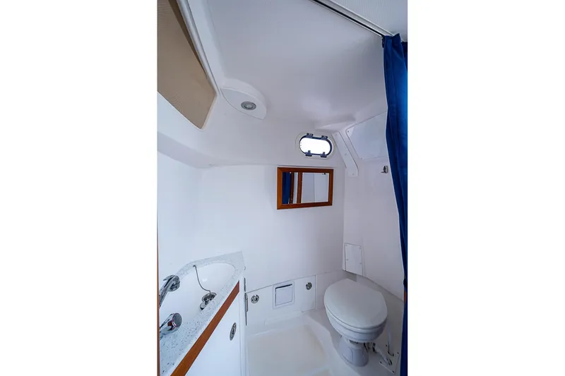 Slide: The Image of 2018 Hunt Yachts 32 Center Console bathroom with sink, toilet, and porthole window. - 18