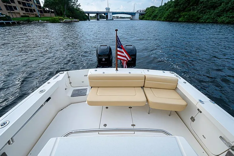 Slide: The Image of 2018 Hunt Yachts 32 Center Console with seating and American flag on a calm river. - 4