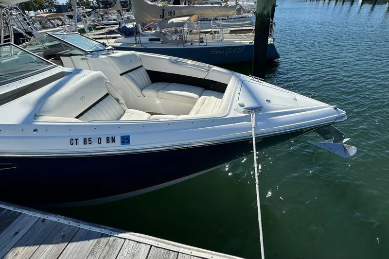 Slide: The Image of 2013 Cobalt 336 boat docked, featuring white seating and sleek design. - 2