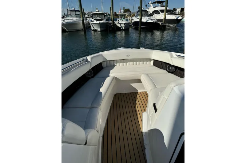 Slide: The Image of 2013 Cobalt 336 boat interior with white seating and wooden deck, docked at marina. - 8