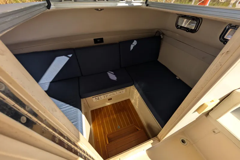 Slide: The Image of Interior of 2004 Albin 30 Family Cruiser with blue seating and wooden flooring. - 27