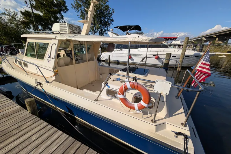 Slide: The Image of 2004 Albin 30 Family Cruiser docked, featuring American flag and life preserver. - 39
