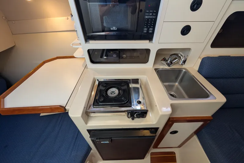 Slide: The Image of Compact kitchen in a 2004 Albin 30 Family Cruiser with stove, sink, and microwave. - 4