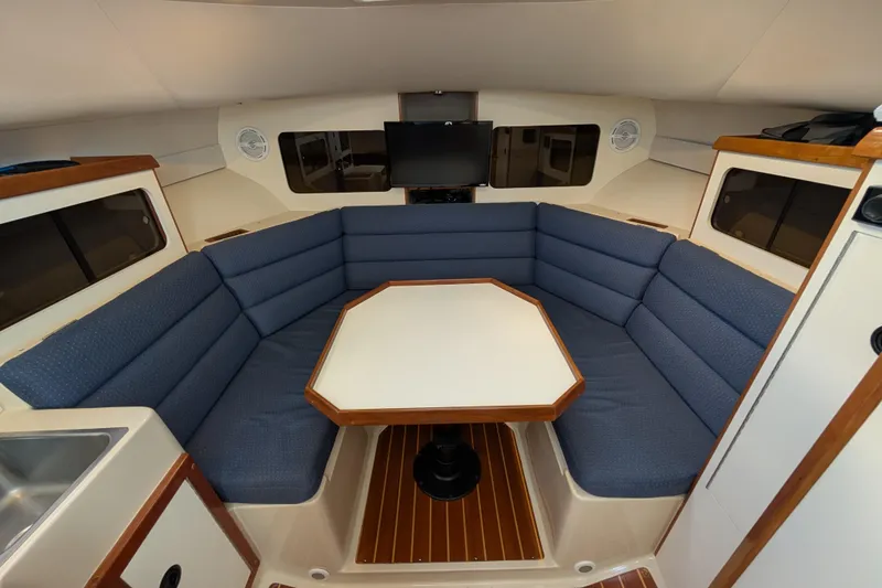 Slide: The Image of Interior of 2004 Albin 30 Family Cruiser with blue seating and a central table. - 5