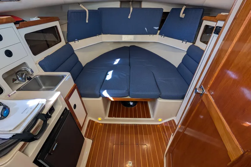 Slide: The Image of Interior of 2004 Albin 30 Family Cruiser with blue seating and compact kitchenette. - 9