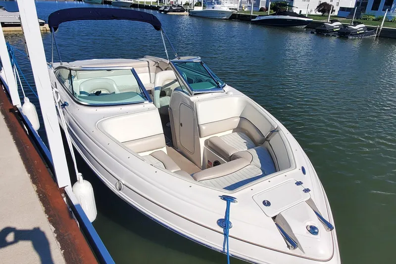 Slide: The Image of 2007 Bryant 219 boat docked on calm water, featuring sleek design and spacious seating. - 3