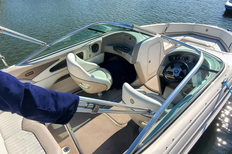 Slide: The Image of 2007 Bryant 219 boat interior with steering wheel and seating on water. - 4