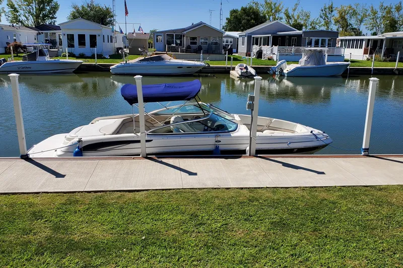 Slide: The Image of 2007 Bryant 219 boat docked by waterfront homes on a sunny day. - 6