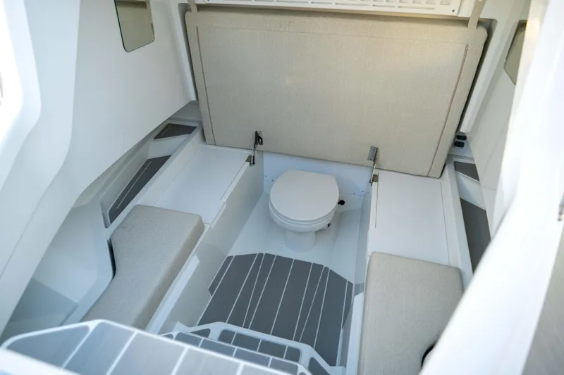 Slide: The Image of Interior of 2026 Wellcraft 28 T-Top boat featuring a compact marine toilet. - 19