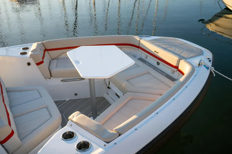 Slide: The Image of 2026 Wellcraft 28 T-Top boat interior with seating and table, docked on calm water. - 26
