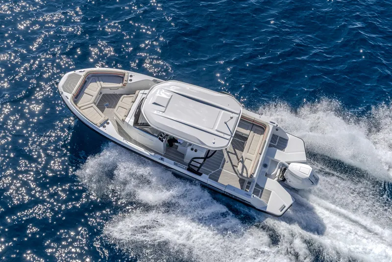 Slide: The Image of 2026 Wellcraft 28 T-Top boat cruising on sparkling blue ocean waters. - 33