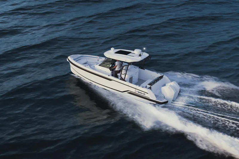 Slide: The Image of 2026 Wellcraft 28 T-Top boat cruising on open water, showcasing sleek design and performance. - 7