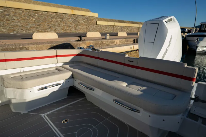 Slide: The Image of 2026 Wellcraft 28 T-Top boat interior with cushioned seating and Mercury engine. - 8