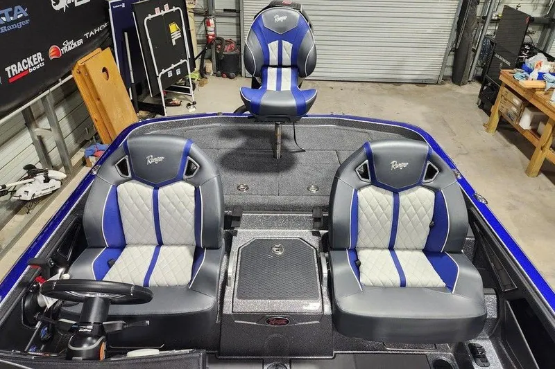 Slide: The Image of 2026 Ranger Z521R Cup-Equipped boat interior with blue and gray seating in a garage. - 10