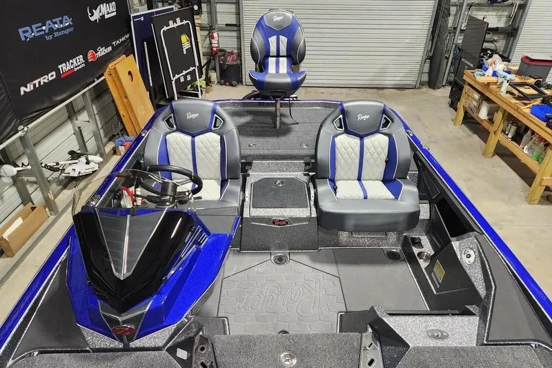 Slide: The Image of 2026 Ranger Z521R Cup-Equipped boat interior with blue and gray seating in a garage. - 7