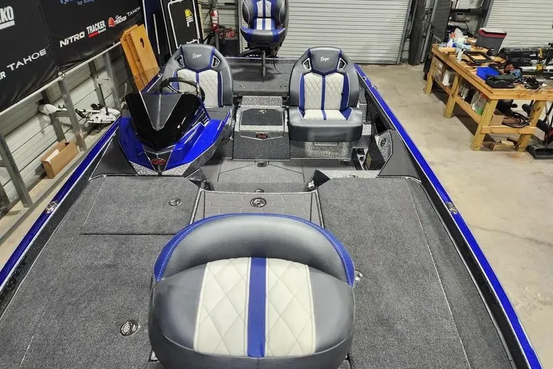 Slide: The Image of 2026 Ranger Z521R Cup-Equipped boat interior with blue and white seating in a workshop. - 8
