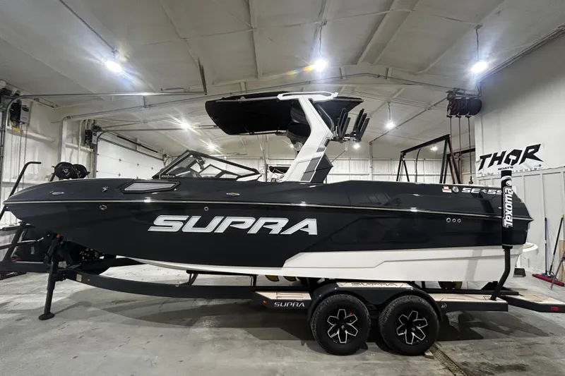 Slide: The Image of 2026 Supra SE boat in a showroom, black and white design, on a trailer. - 4