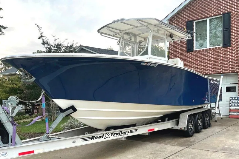 The Image of 2005 Southport 28 Center Console boat on trailer, parked in driveway. - 0