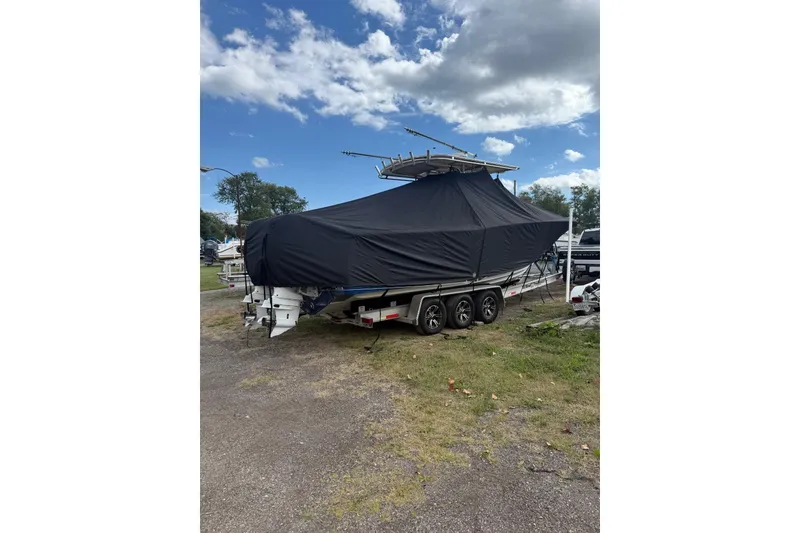Slide: The Image of Covered 2005 Southport 28 Center Console boat on a trailer under a cloudy sky. - 12