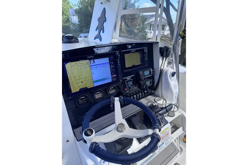 Slide: The Image of 2005 Southport 28 Center Console boat dashboard with navigation equipment and steering wheel. - 17