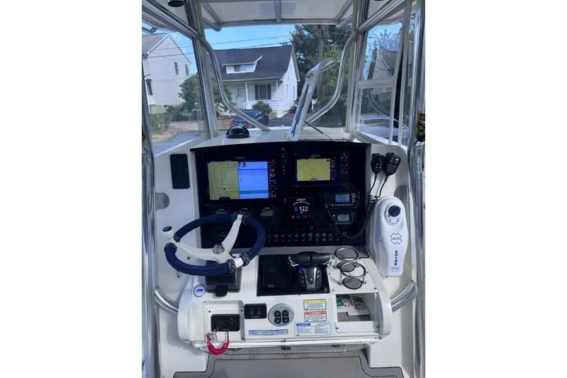 Slide: The Image of 2005 Southport 28 Center Console boat dashboard with navigation screens and controls. - 19