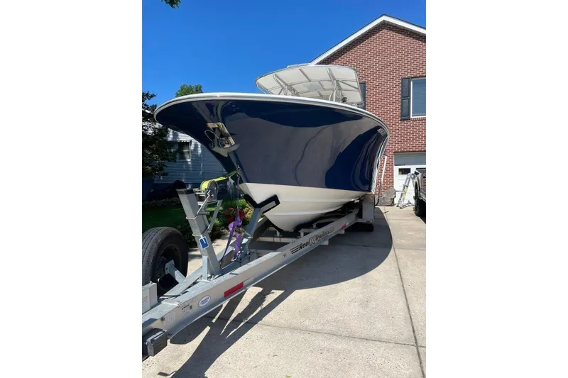 Slide: The Image of 2005 Southport 28 Center Console boat on trailer in driveway, blue hull, sunny day. - 2