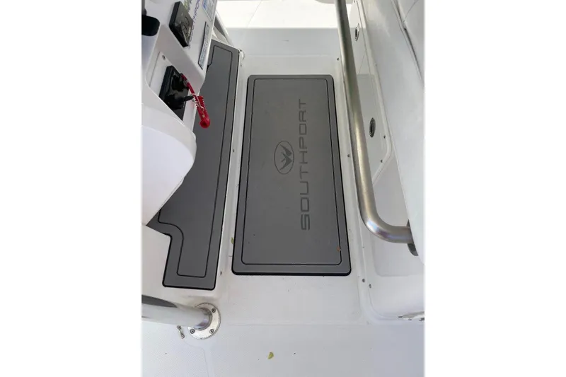 Slide: The Image of 2005 Southport 28 Center Console boat interior with branded floor mat and control panel. - 25