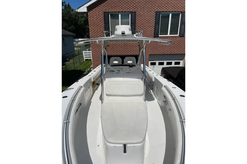 Slide: The Image of 2005 Southport 28 Center Console boat with white seating, docked near a brick house. - 29