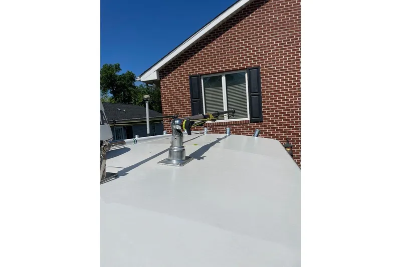 Slide: The Image of 2005 Southport 28 Center Console boat with fishing rod holder, near brick house. - 30