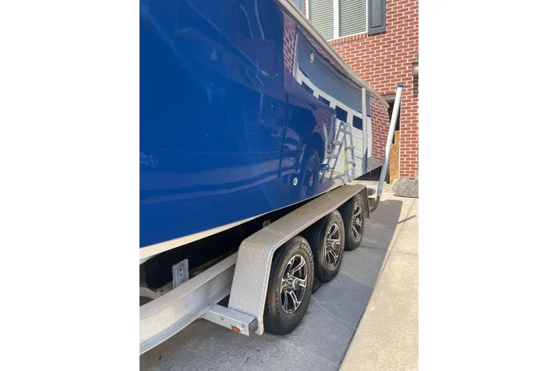 Slide: The Image of 2005 Southport 28 Center Console boat on a trailer, parked near a brick building. - 4