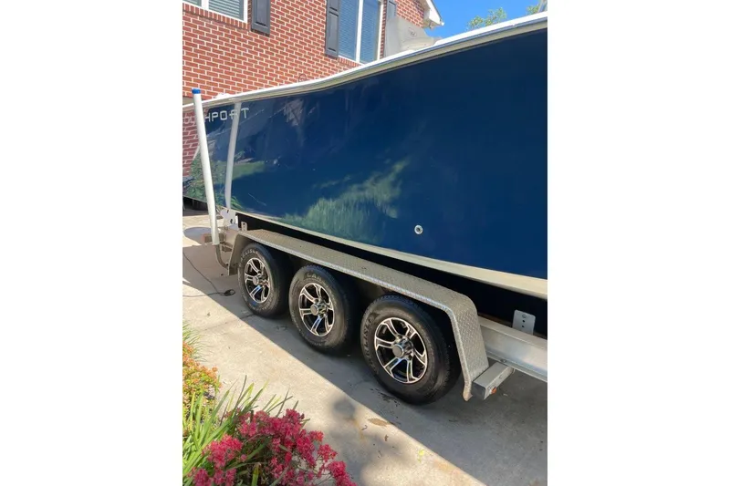 Slide: The Image of 2005 Southport 28 Center Console boat on a trailer, parked near a brick building. - 6